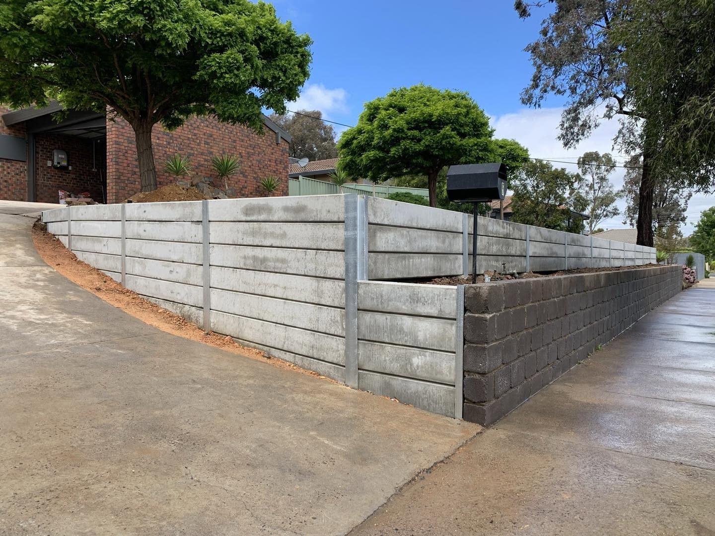 A concrete sleeper retaining wall beside a new driveway