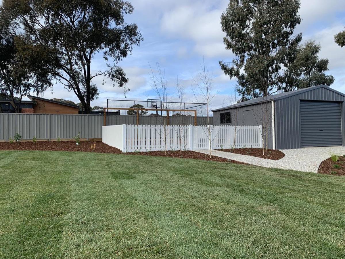 A grey Colorbond fence running the length of a back lawn