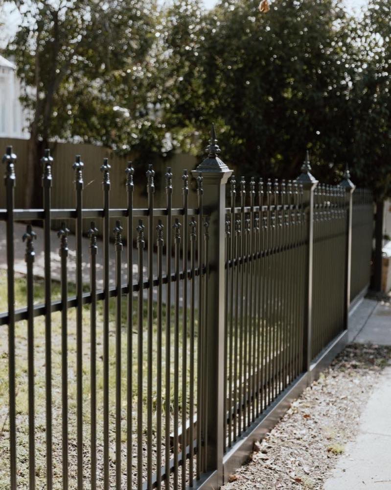 A black powder-coated aluminium fence and matching gate along a footpath