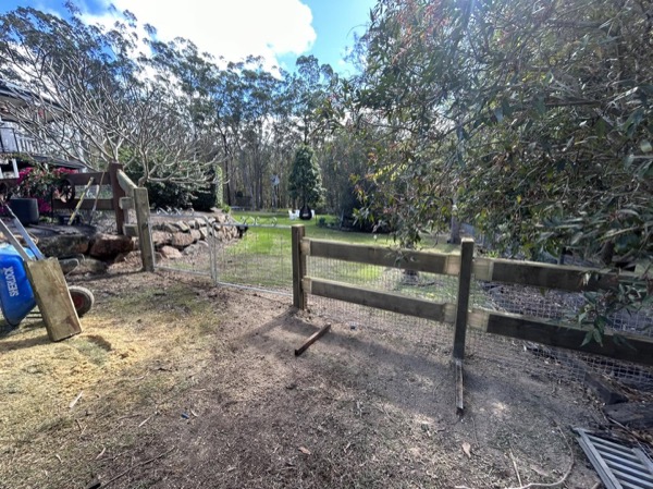 Timber posts and rails part-way through a rural fence build