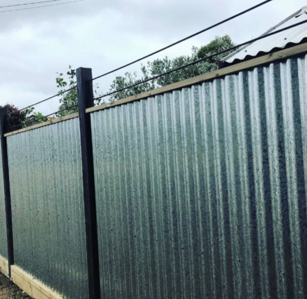 A close view of dark green Colorbond sheeting and its capping