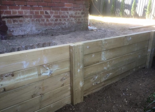 A timber sleeper retaining wall built along a back boundary