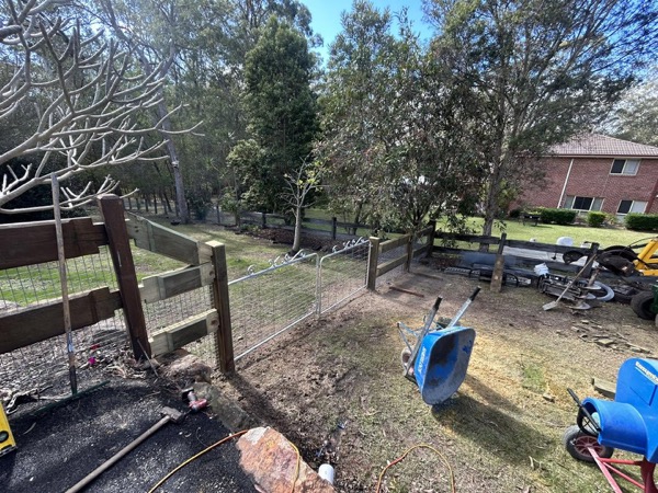 Timber rails fixed to new posts part-way through a fence build
